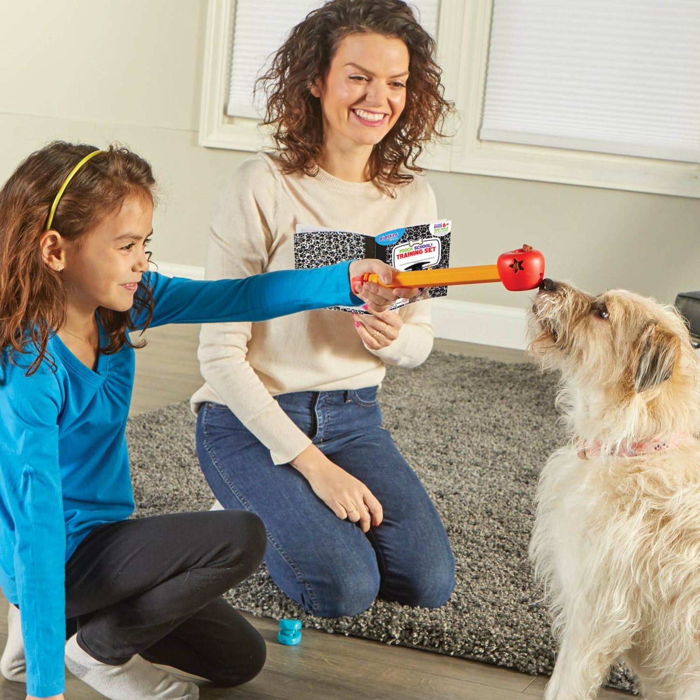 Pretty woman and young girl playing training a cream coloured dog with the Brightkins pooch school training set.